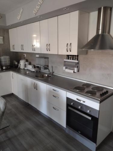 a kitchen with white cabinets and a stove top oven at Mare kuća za odmor in Šibenik