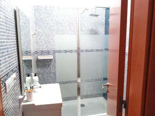 a bathroom with a glass shower with a sink at CASA MIRAMAR in Corralejo
