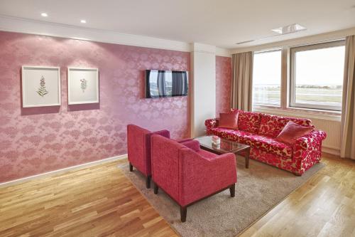 a living room with a red couch and chairs at Reykjavik Natura - Berjaya Iceland Hotels in Reykjavík