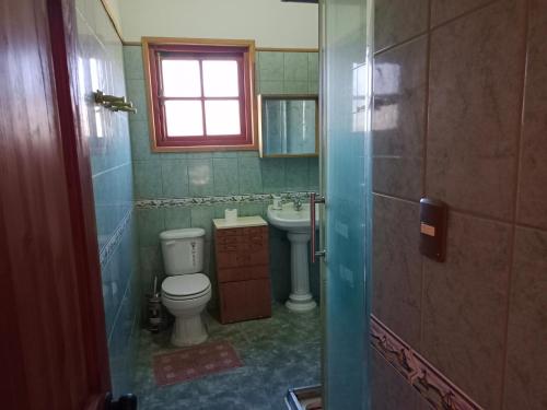 baño con aseo y lavabo y ventana en La Milagrera Olmué, en Quebrada de Alvarado