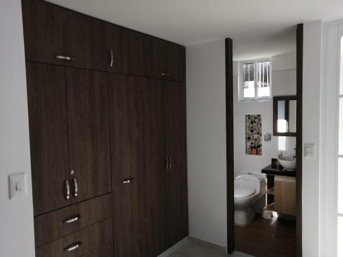 ein Badezimmer mit Holzschränken und einem WC in der Unterkunft Hermoso apartamento familiar con parqueadero privado in San Gil