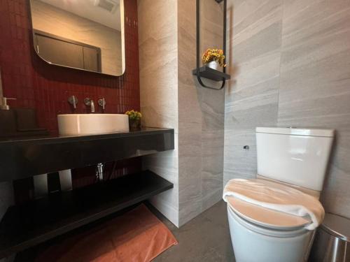 a bathroom with a white toilet and a sink at The Edge central pattaya in Pattaya Central
