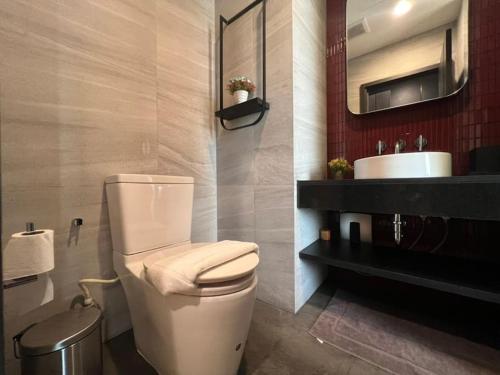 a bathroom with a white toilet and a sink at The Edge central pattaya in Pattaya Central