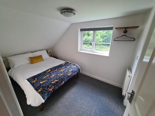 a small bedroom with a bed and a window at Park House Self-Contained Annex in Mold