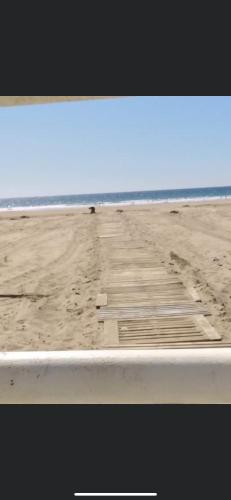 a view of a beach with a wooden pier at Chez Dany à Residence Beralmar in Asilah