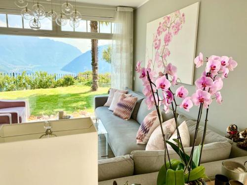 a living room with a couch and pink flowers at Single family house with lake view in Carona in Lugano