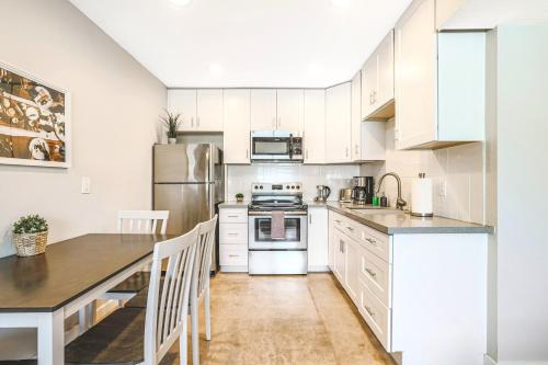 a kitchen with white cabinets and a table with chairs at LaRocco On Turney Biltmore in Phoenix