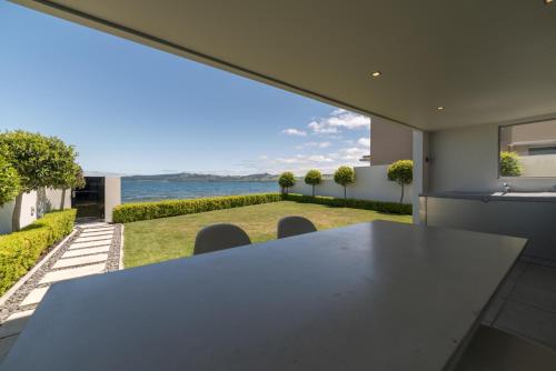 a dining room with a table and a view of the ocean at Sacred Waters Taupo in Taupo