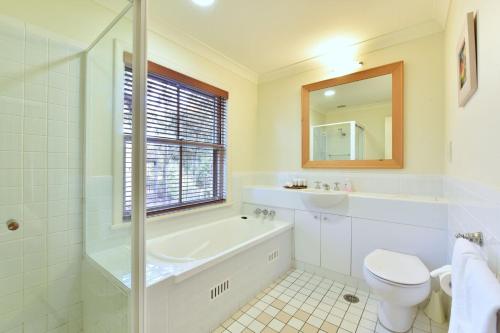 ポーコルビンにあるVilla 2br Rose Villa located within Cypress Lakes Resortの浴槽、トイレ、洗面台を備えたバスルーム