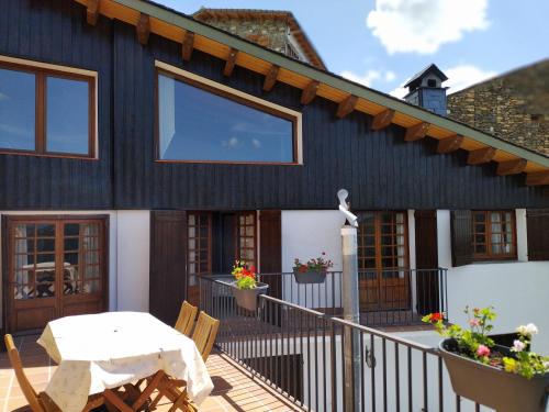 Los MolinosにあるCasa rural con vistas en el corazón del Pirineoのバルコニーとテーブル付きのデッキが備わる家