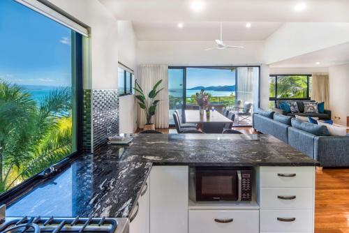an open kitchen and living room with a view of the ocean at Pinnacle Apartments on Hamilton Island by HIHA in Hamilton Island