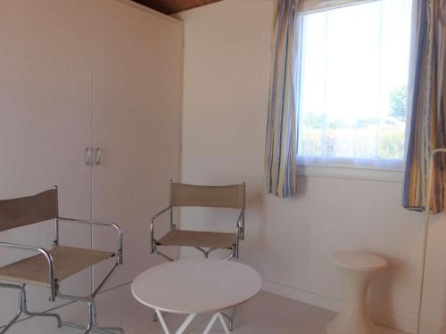 une chambre avec deux chaises, une table et une fenêtre dans l'établissement Maison 3 pièces pour 5 personnes à 1,5 km de la mer avec piscine, tennis et parking privé - FR-1-224A-58, à Bretignolles-sur-Mer