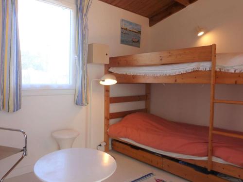 une chambre avec deux lits superposés et une table dans l'établissement Maison 3 pièces pour 5 personnes à 1,5 km de la mer avec piscine, tennis et parking privé - FR-1-224A-58, à Bretignolles-sur-Mer