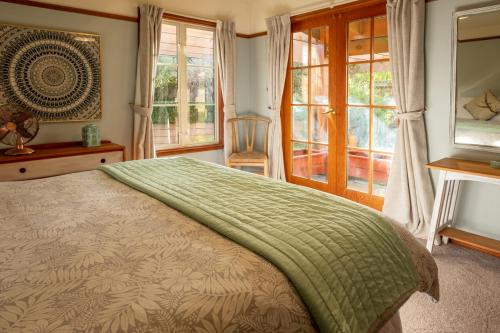 een slaapkamer met een bed met een groene deken erop bij 37 St James Avenue in Hanmer Springs