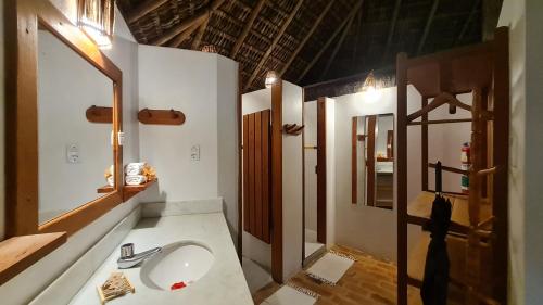 a bathroom with a sink and a mirror at Aldeia Setemares Bangalôs in Serra Grande