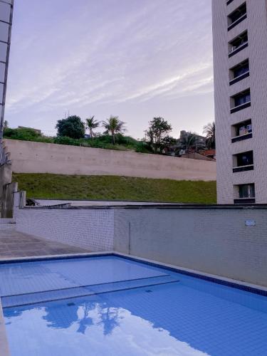 an empty swimming pool in front of a building at Acomodação aconchegante à beira- mar in Natal