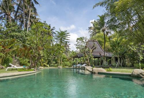 a pool of water in front of a house at Korurua Dijiwa Ubud in Ubud