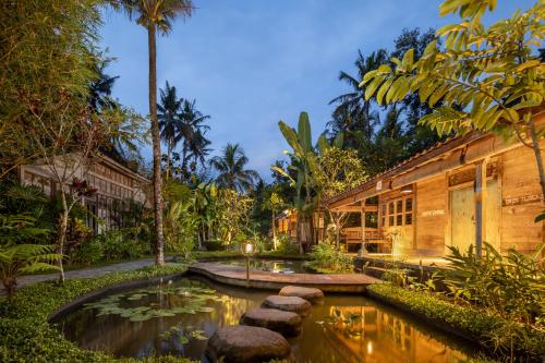 un jardín con un estanque frente a un edificio en Korurua Dijiwa Ubud en Ubud