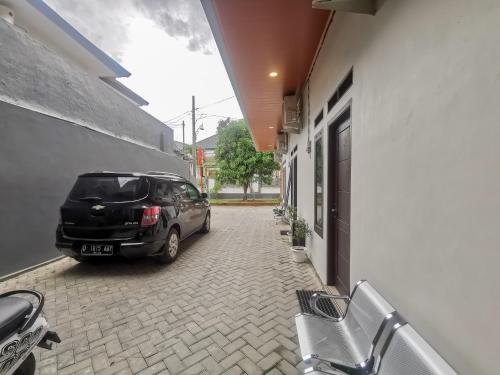 a car parked in a parking lot next to a building at RedDoorz @ Jalan Urip Sumoharjo Lampung in Kedaton