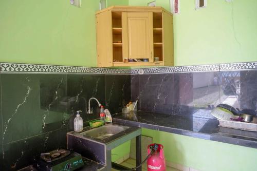 a kitchen with a sink and a counter top at KoolKost Syariah near Living Plaza Purwokerto (minimum stay 6 nights) in Purwokerto