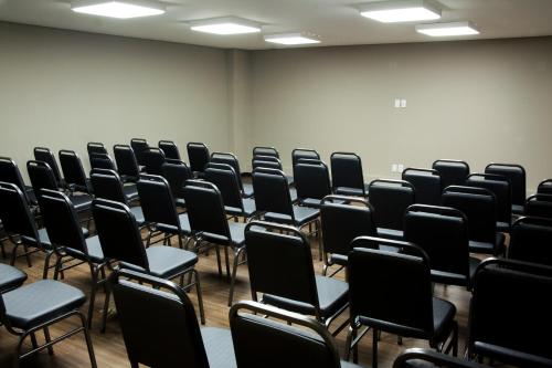 an empty room with black chairs in it at BH Raja Hotel in Belo Horizonte