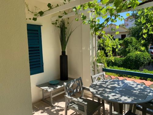 a patio with a table and chairs and a vase at Cozy D&D in Jelsa