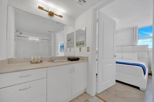 a white bathroom with a sink and a bed at 40th Floor Priceless Unit Central Location in Miami
