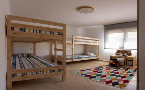 a room with two bunk beds and a rug at Casa Viturna in O Grove