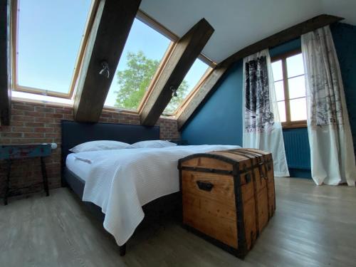 Penzion Na Červeném Potoce في كراليكي: غرفة نوم بسرير كبير مع أرضية خشبية