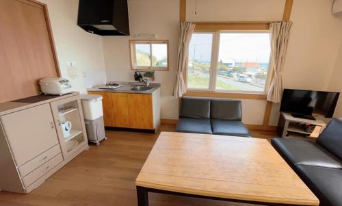 a living room with a couch and a table at BBQ & Rental Villa Palm Village in Minamiboso