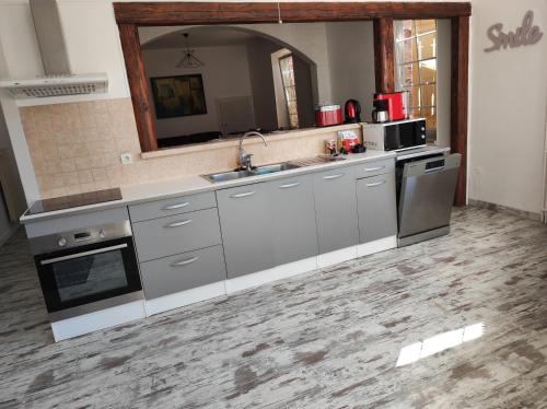 kuchnia z urządzeniami ze stali nierdzewnej i lustrem w obiekcie Gîte "fils et cotons" Piscine Intérieure chauffée à l'année et sauna privé w mieście Celles-sur-Plaine