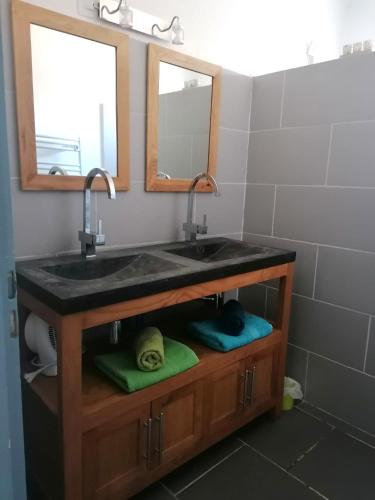 La salle de bains est pourvue d'un lavabo, de 2 miroirs et de serviettes. dans l'établissement La Maison du soleil & du sourire, à Nîmes