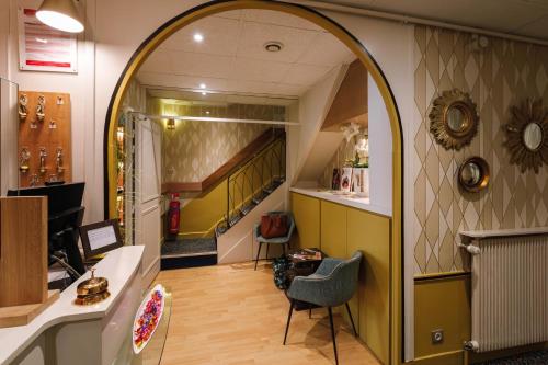 an office with an archway and a hallway with a staircase at Hôtel du Dauphin in Lyon