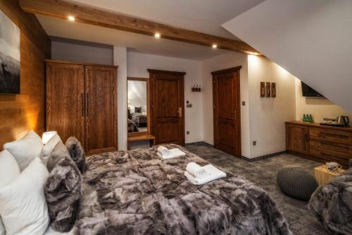 a bedroom with a bed with a book on it at Pensjonat Orlik Mountain Resort&SPA in Bukowina Tatrzańska