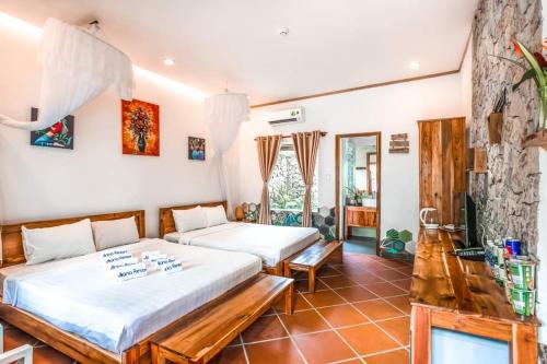 1 dormitorio con 2 camas y TV. en Miana Resort Phu Quoc, en Phu Quoc