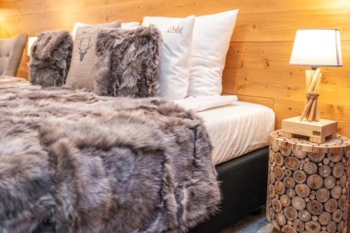 a bed with a blanket and a lamp on a table at Pensjonat Orlik Mountain Resort&SPA in Bukowina Tatrzańska