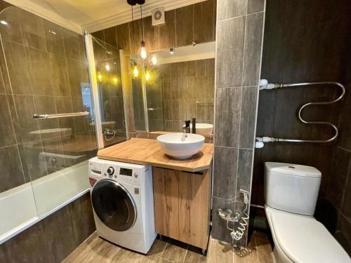 a bathroom with a washing machine and a sink at Новостройка с дизайнерским ремонтом in Petropavlovsk