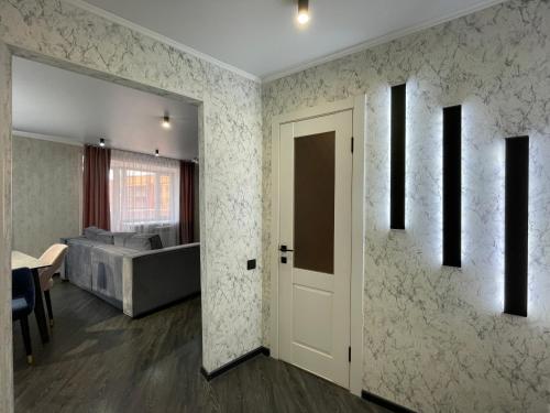 a room with a door and a bedroom with a bed at Новостройка с дизайнерским ремонтом in Petropavlovsk