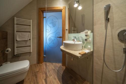 a bathroom with a toilet sink and a blue door at Pensjonat Orlik Mountain Resort&SPA in Bukowina Tatrzańska