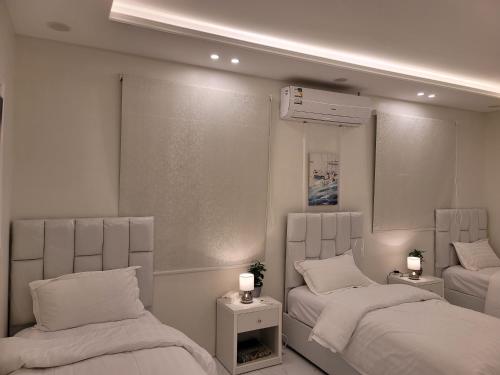 a bedroom with two beds and a air compressor at دور فخم ومتكامل بالقرب من عسير مول in ‘Aryam