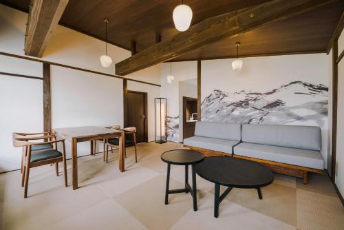 a living room with a couch and a table at SKI INN HAKUBA in Otari