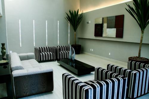 a living room with a couch and chairs and a table at BH Raja Hotel in Belo Horizonte
