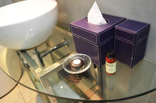 a glass table with a candle and a bowl and a bottle at Wyndham Grand Bangsar Kuala Lumpur in Kuala Lumpur