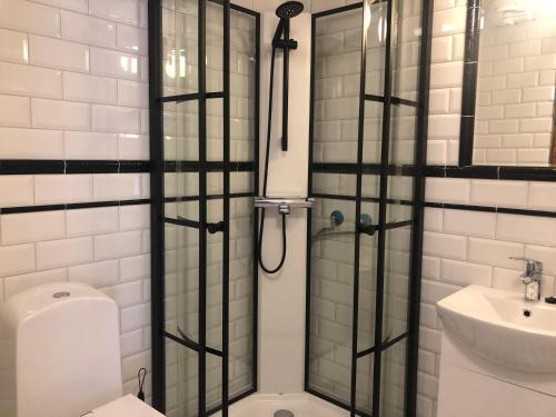 a shower with a glass door in a bathroom at Krepelin Apartments in Kristiinankaupunki