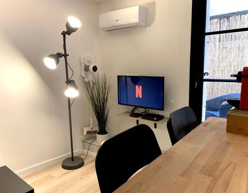 un salon avec une table et une télévision dans l'établissement Petit Studio Terrasse Toulon Vieille Ville, à Toulon