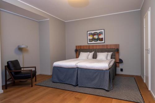 ein Schlafzimmer mit einem Bett und einem Stuhl in der Unterkunft Quality Hotel Park Södertälje City in Södertälje