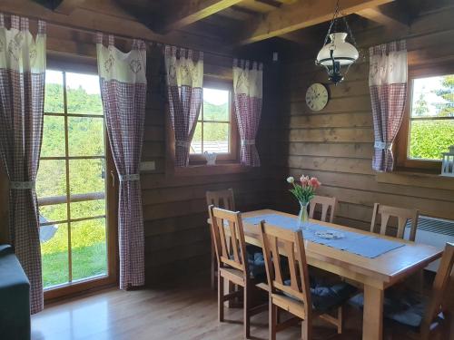 a dining room with a table and chairs and windows at Drevenice Amálka v Terchové in Terchová