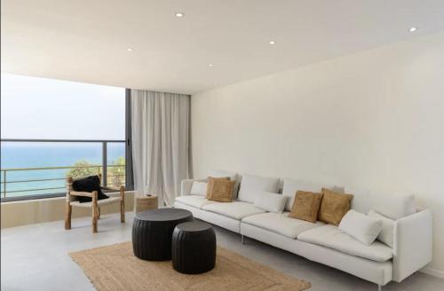 a white living room with a white couch and a table at Stylish & Spacious 3 bedroom apartment by the Sea in Netanya
