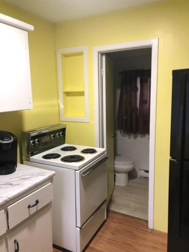a kitchen with a stove and a toilet in it at Wasaga Bridge Cottages in Wasaga Beach