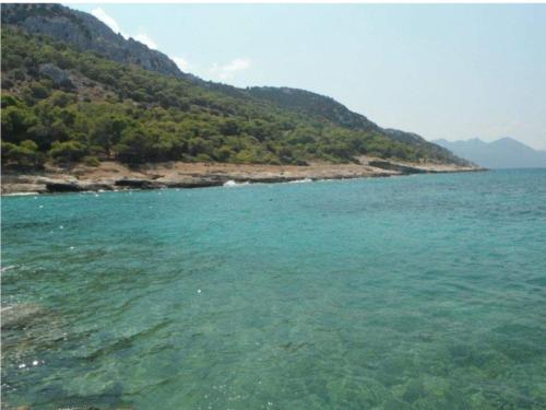 a large body of water next to a mountain at DIMHA Studio in Pýrgos